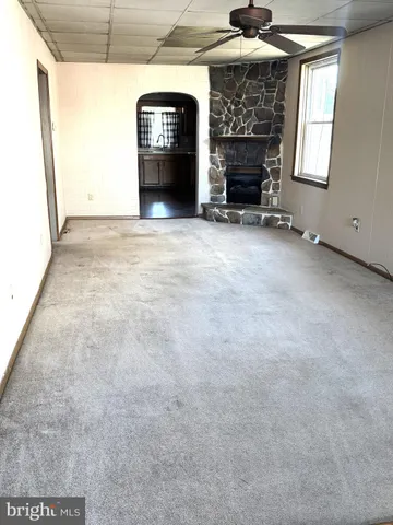 a view of a livingroom with a fireplace and window