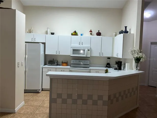 a kitchen with kitchen island stainless steel appliances a sink stove and refrigerator
