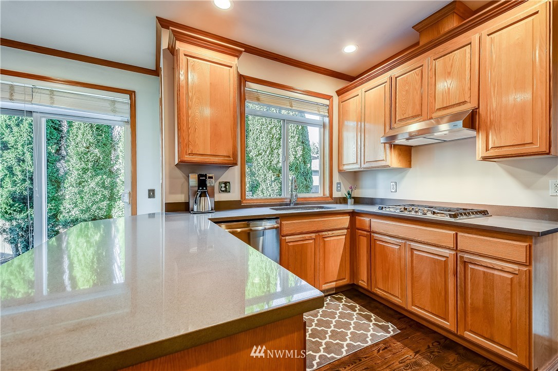 3315 189th Place Southeast Bothell, WA 98012 - Photo 3 of 28 a kitchen with stainless steel appliances granite countertop a refrigerator a sink dishwasher and wooden cabinets with a large window