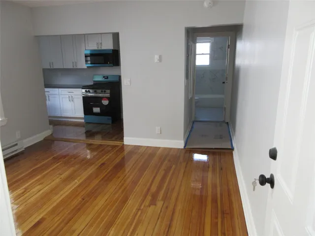 a kitchen with wooden floor and electronic appliances
