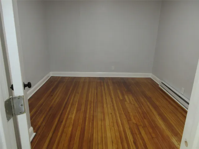 a view of a room with wooden floor and bench