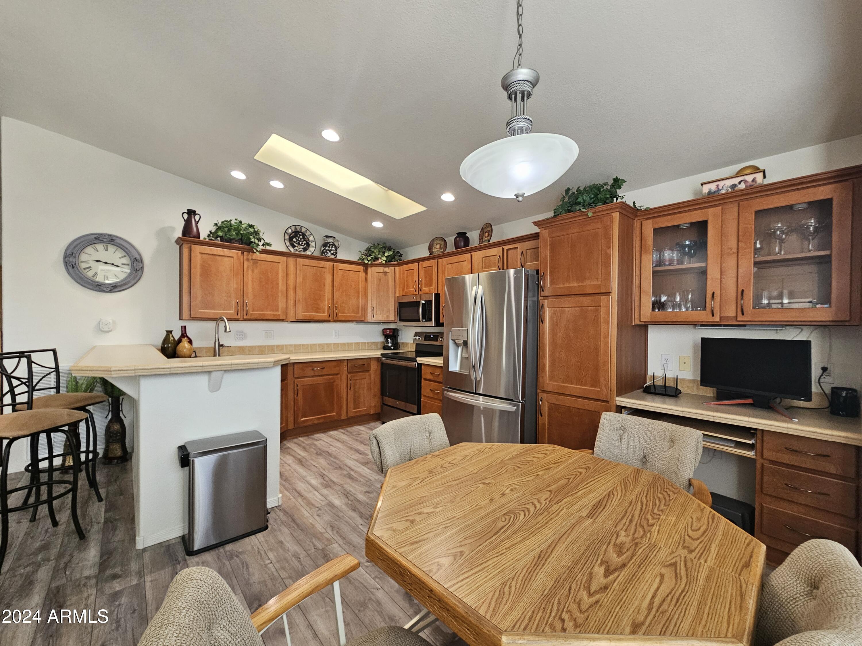 650 North Hawes Road, Unit 4412 Mesa, AZ 85207 - Photo 11 of 48 a kitchen with stainless steel appliances kitchen island granite countertop a refrigerator a stove a sink dishwasher with a dining table and chairs