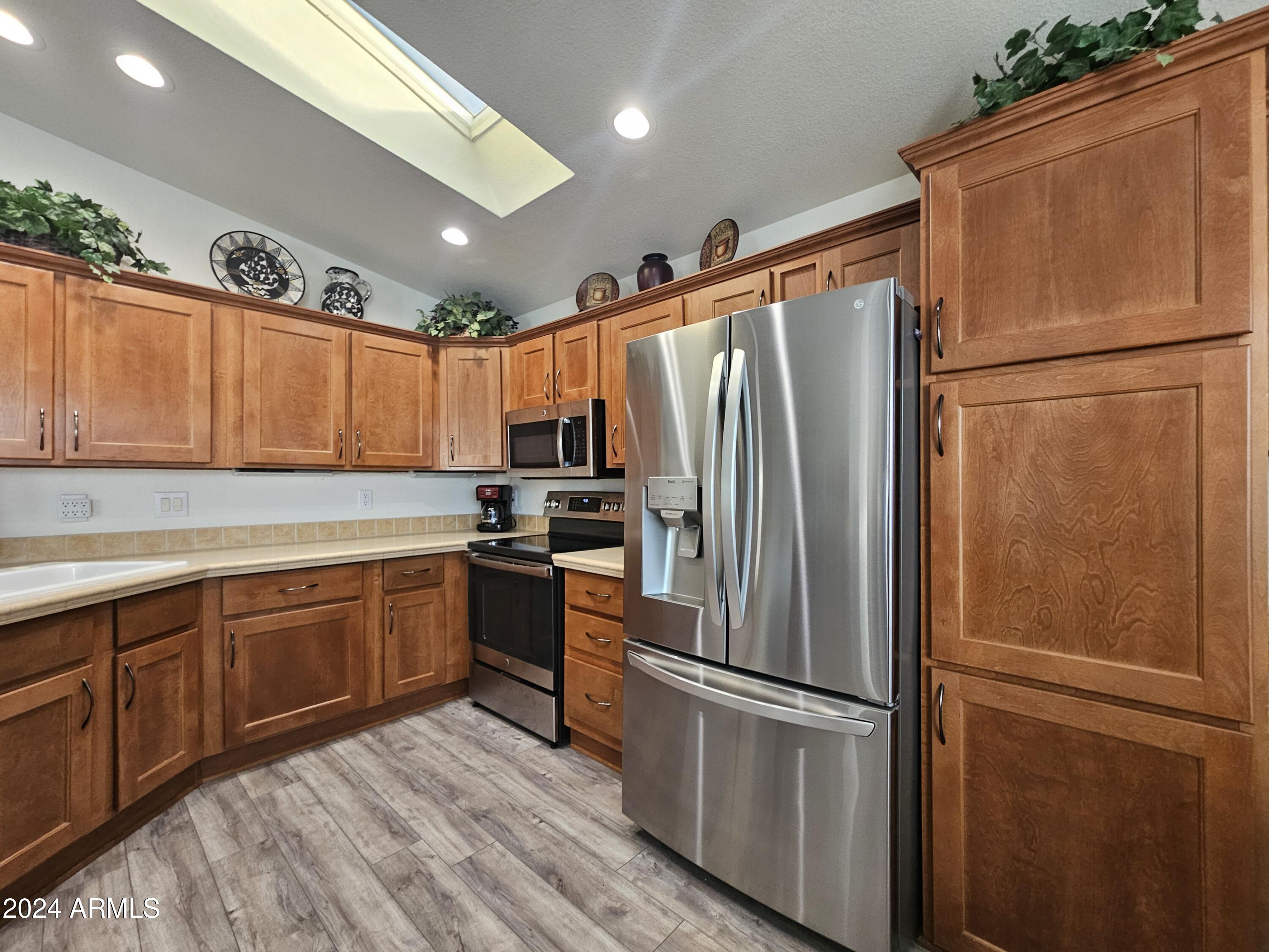650 North Hawes Road, Unit 4412 Mesa, AZ 85207 - Photo 13 of 48 a kitchen with stainless steel appliances granite countertop a refrigerator sink and cabinets