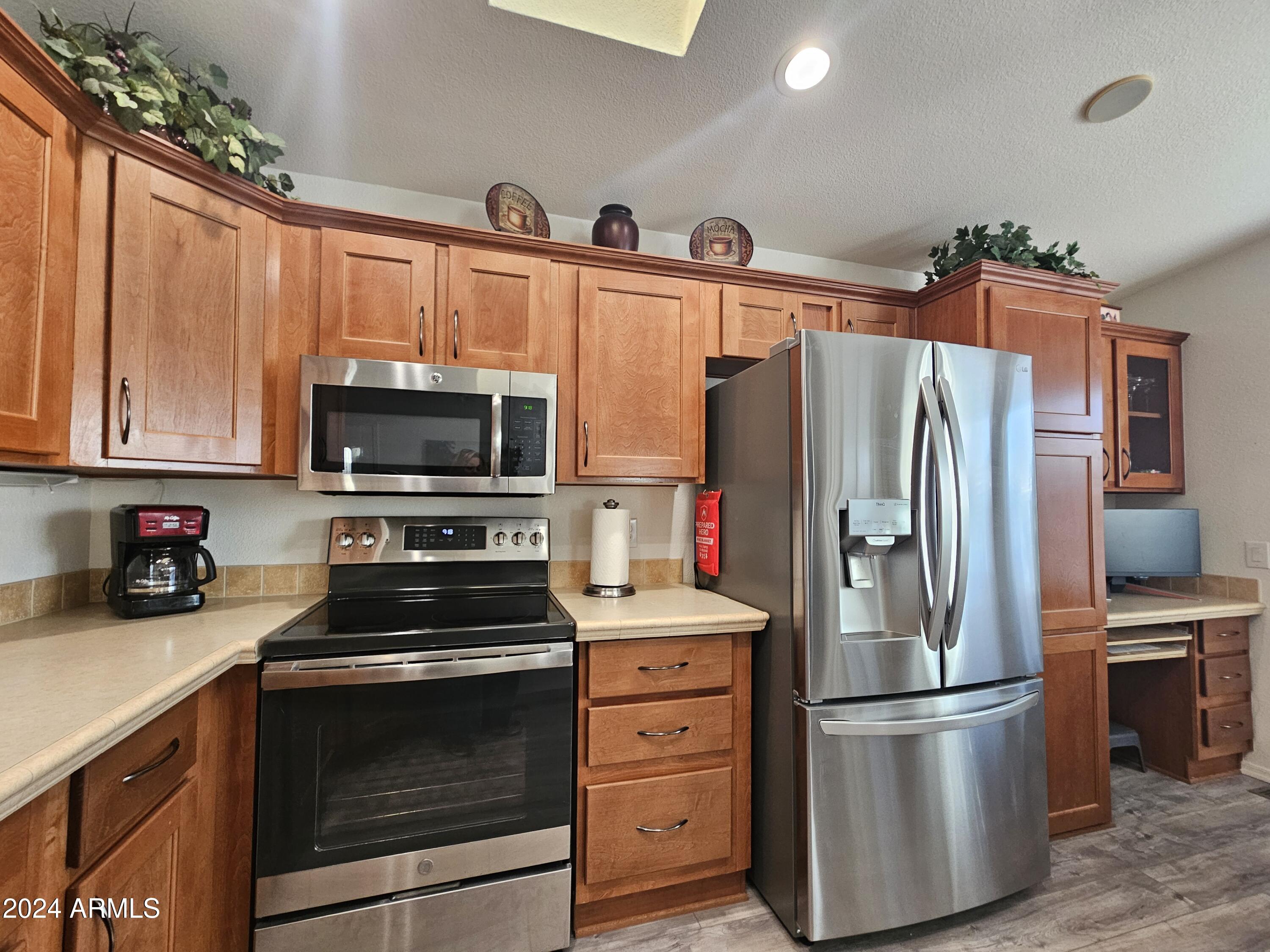 650 North Hawes Road, Unit 4412 Mesa, AZ 85207 - Photo 14 of 48 a kitchen with stainless steel appliances a refrigerator stove and microwave