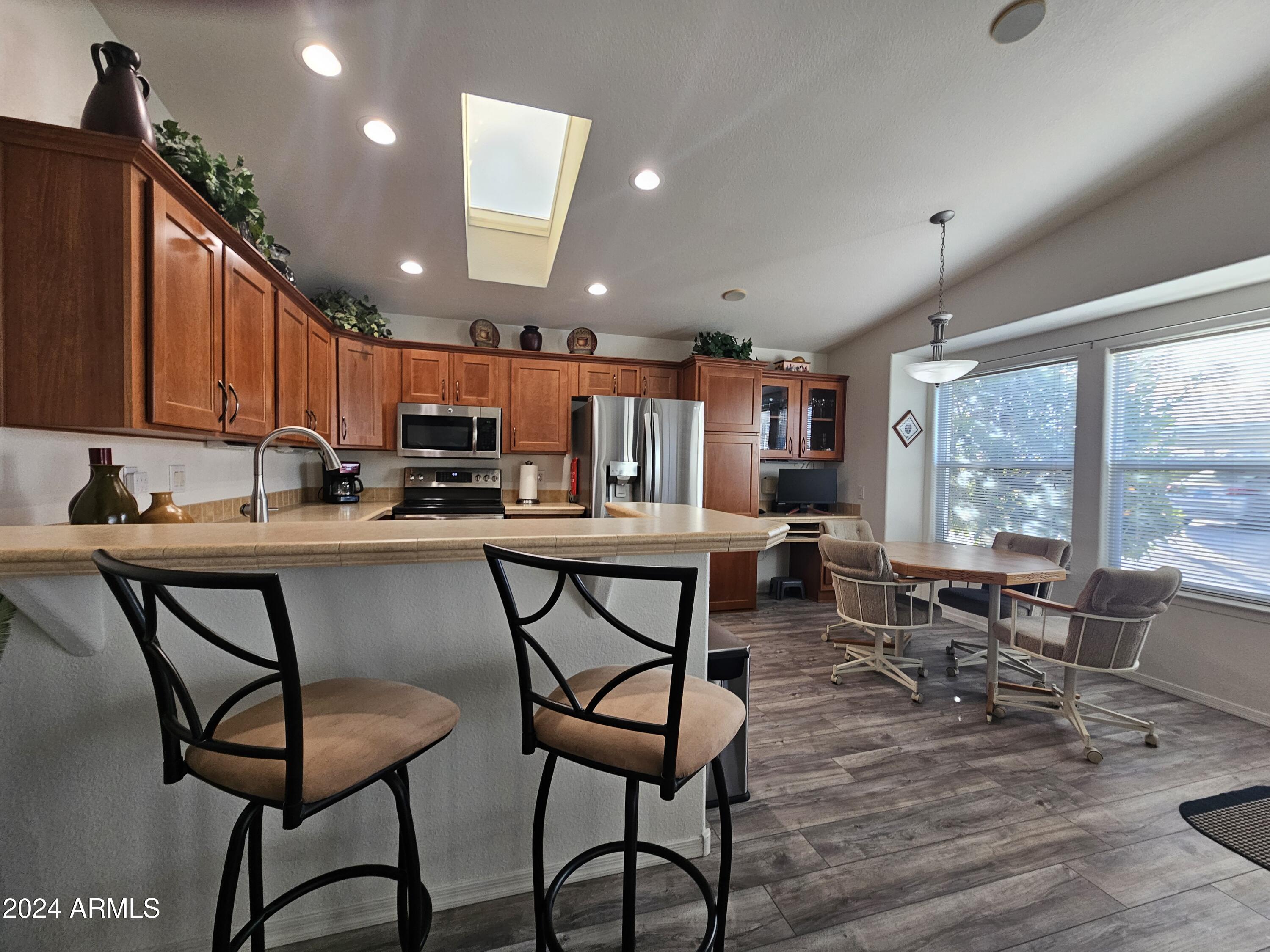 650 North Hawes Road, Unit 4412 Mesa, AZ 85207 - Photo 16 of 48 a kitchen with stainless steel appliances granite countertop table chairs sink and window