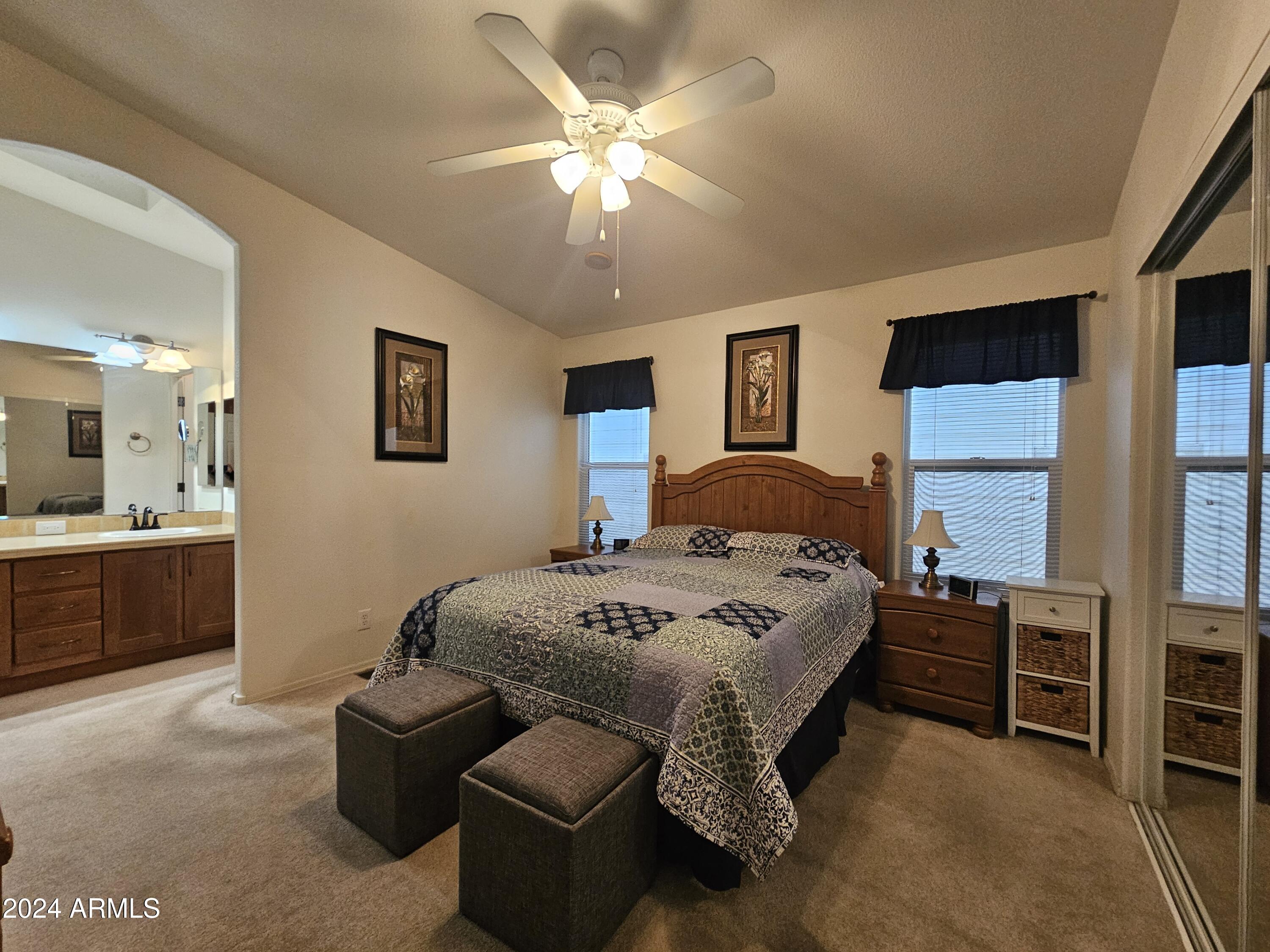 650 North Hawes Road, Unit 4412 Mesa, AZ 85207 - Photo 17 of 48 a spacious bedroom with a bed a chandelier and dresser
