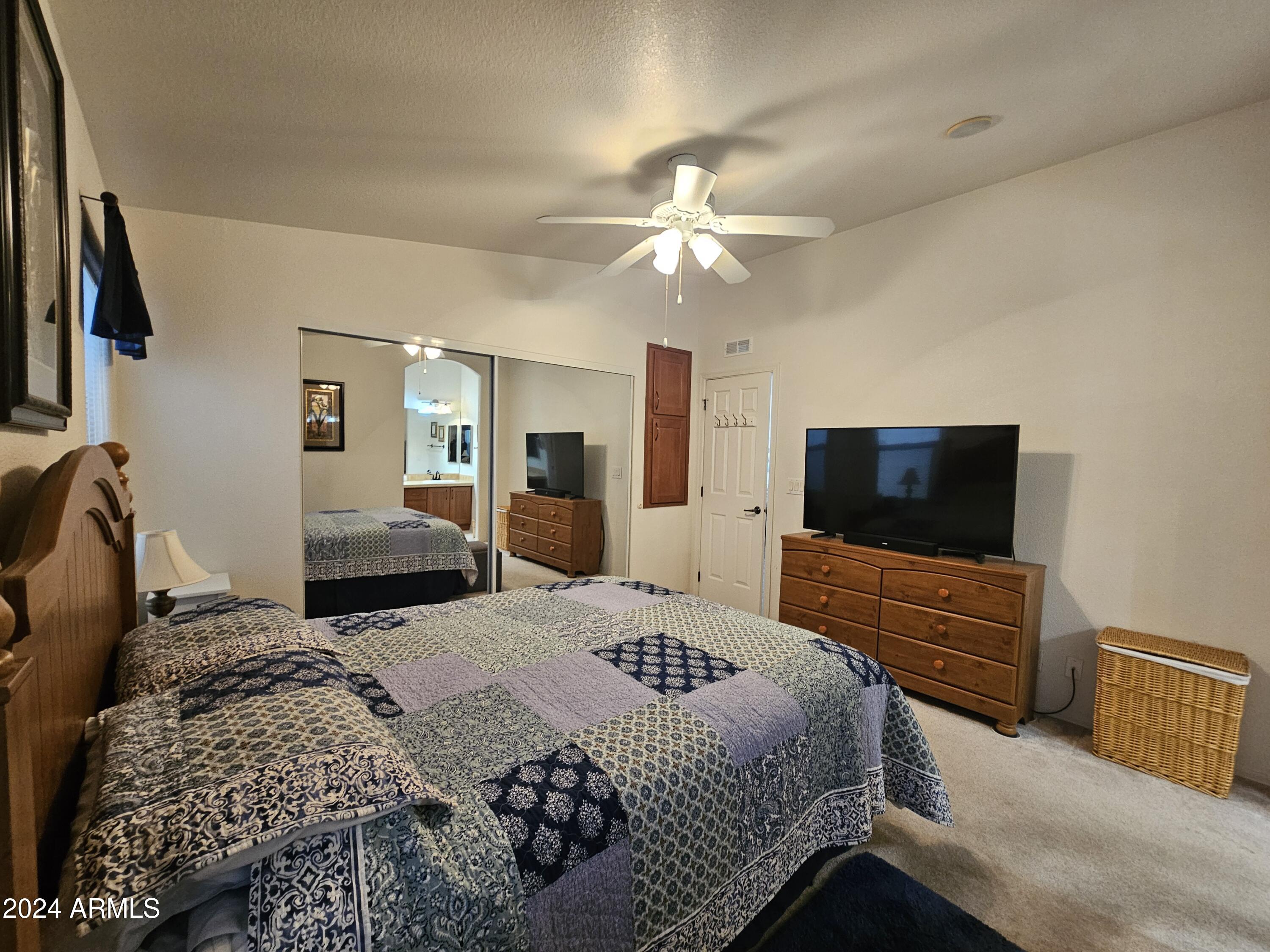 650 North Hawes Road, Unit 4412 Mesa, AZ 85207 - Photo 19 of 48 a bedroom with a bed and a flat screen tv