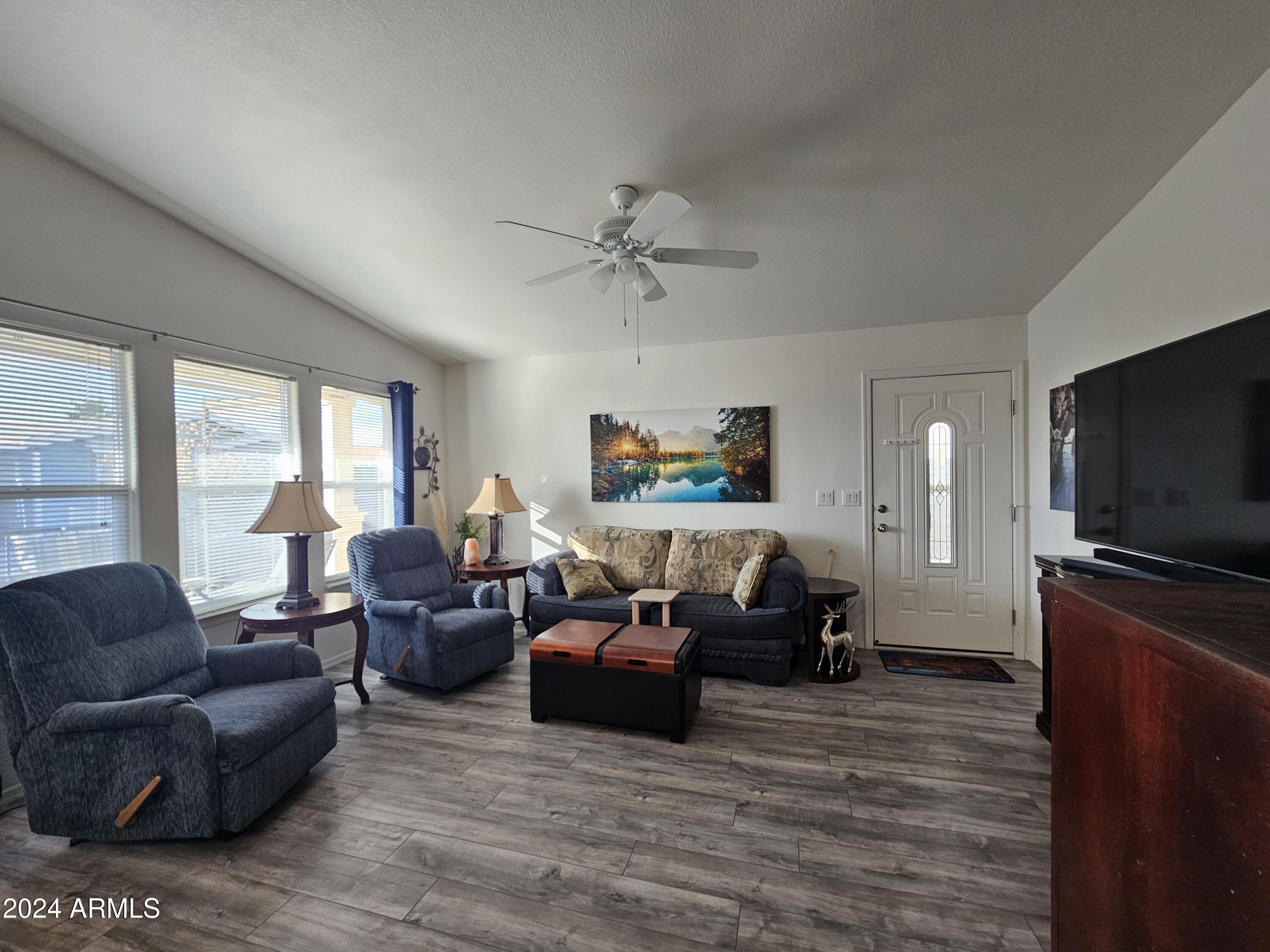 650 North Hawes Road, Unit 4412 Mesa, AZ 85207 - Photo 2 of 48 a living room with furniture and a flat screen tv