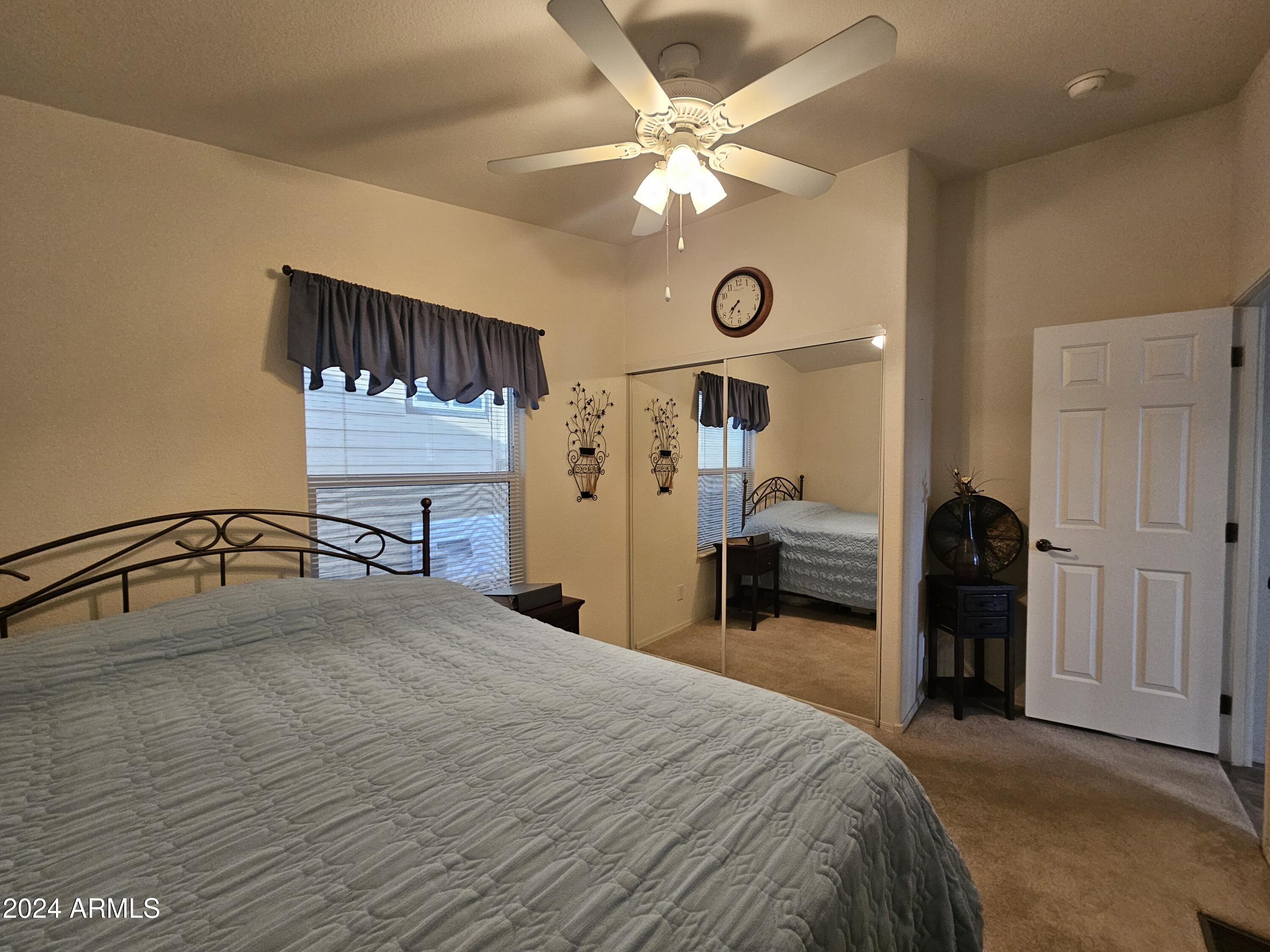 650 North Hawes Road, Unit 4412 Mesa, AZ 85207 - Photo 25 of 48 a bedroom with a bed and a chandelier