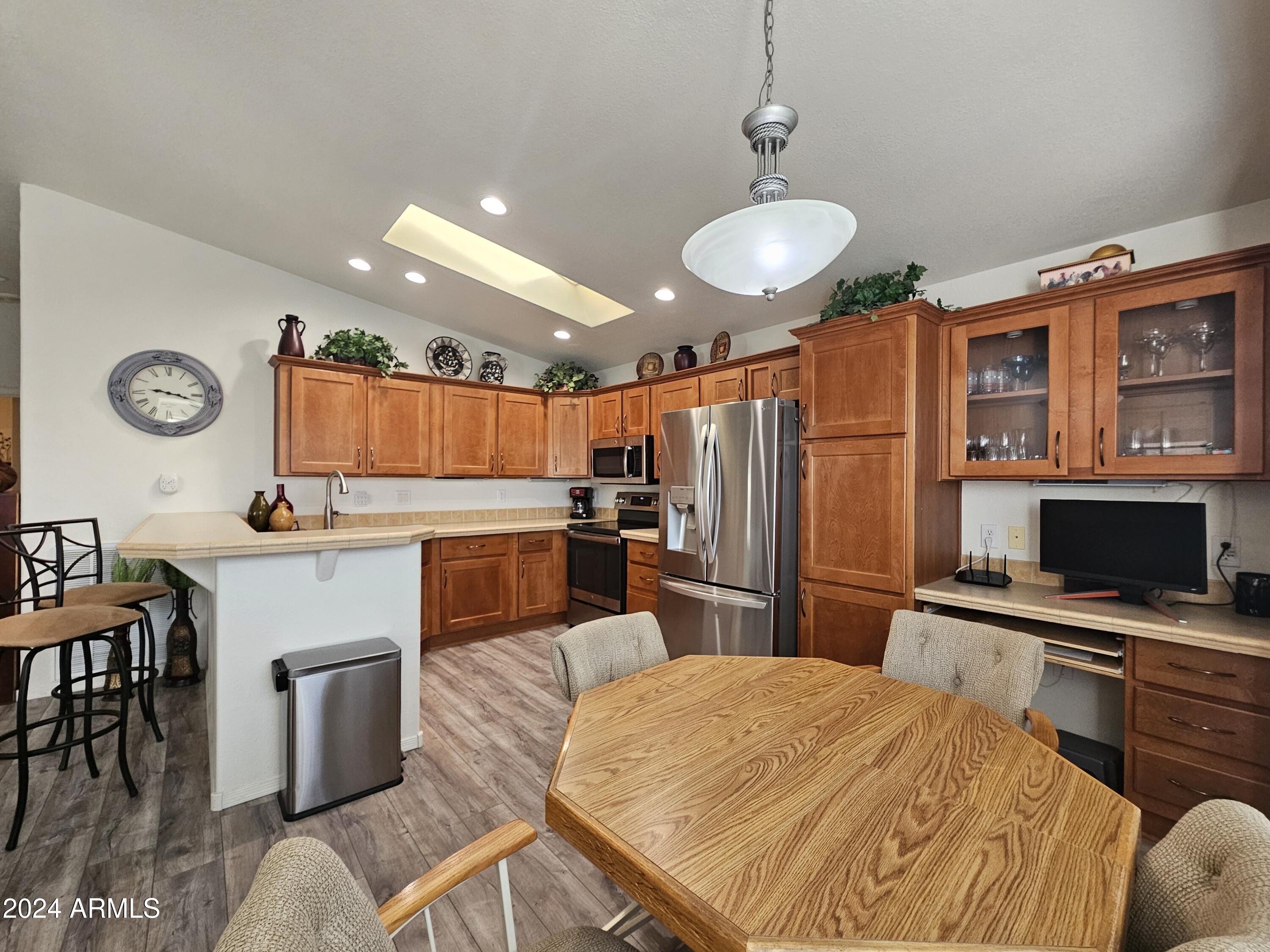 650 North Hawes Road, Unit 4412 Mesa, AZ 85207 - Photo 3 of 48 a kitchen with stainless steel appliances kitchen island granite countertop a sink dishwasher a microwave oven with granite countertops and chairs