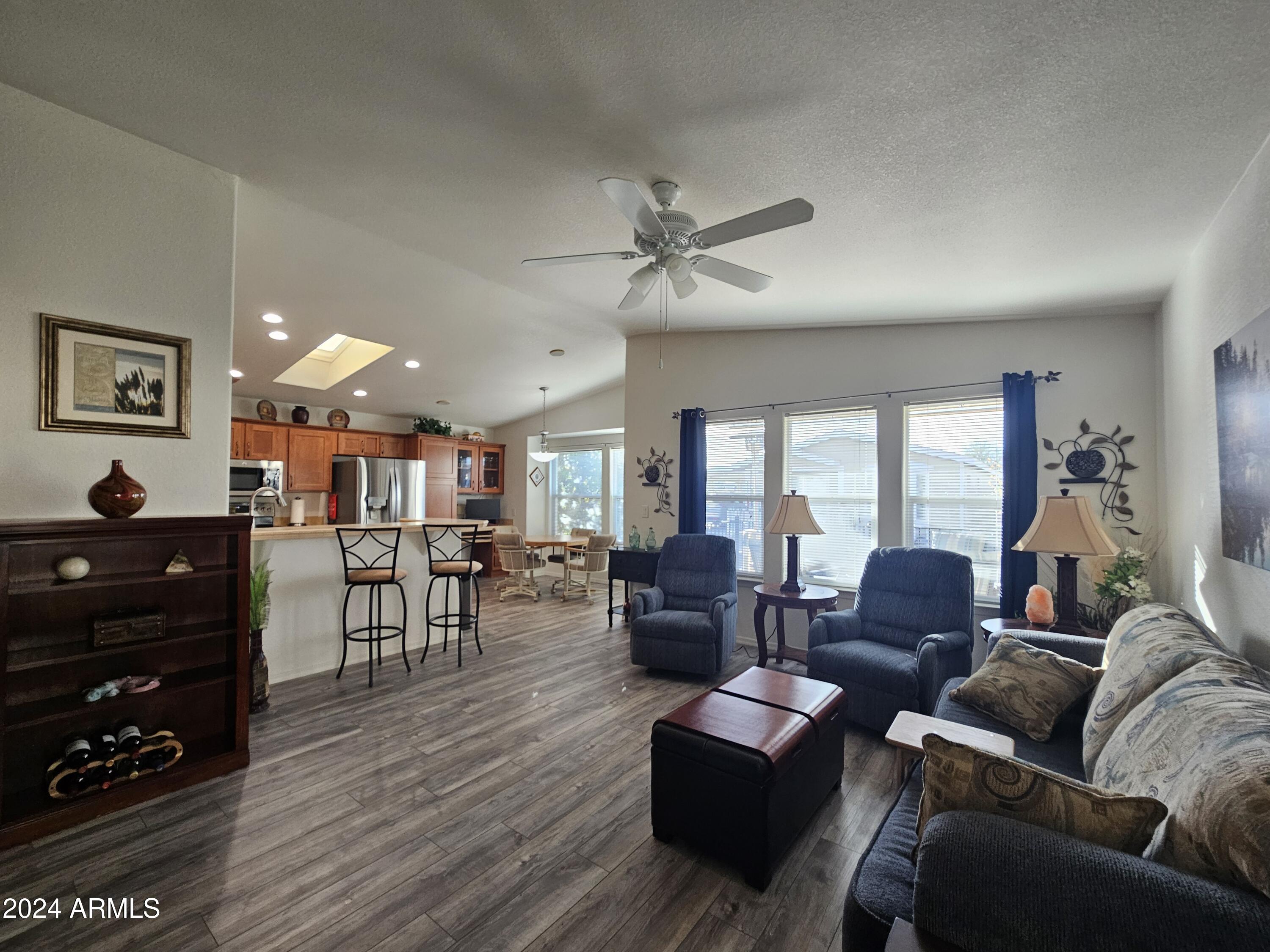 650 North Hawes Road, Unit 4412 Mesa, AZ 85207 - Photo 7 of 48 a living room with furniture a ceiling fan and a flat screen tv