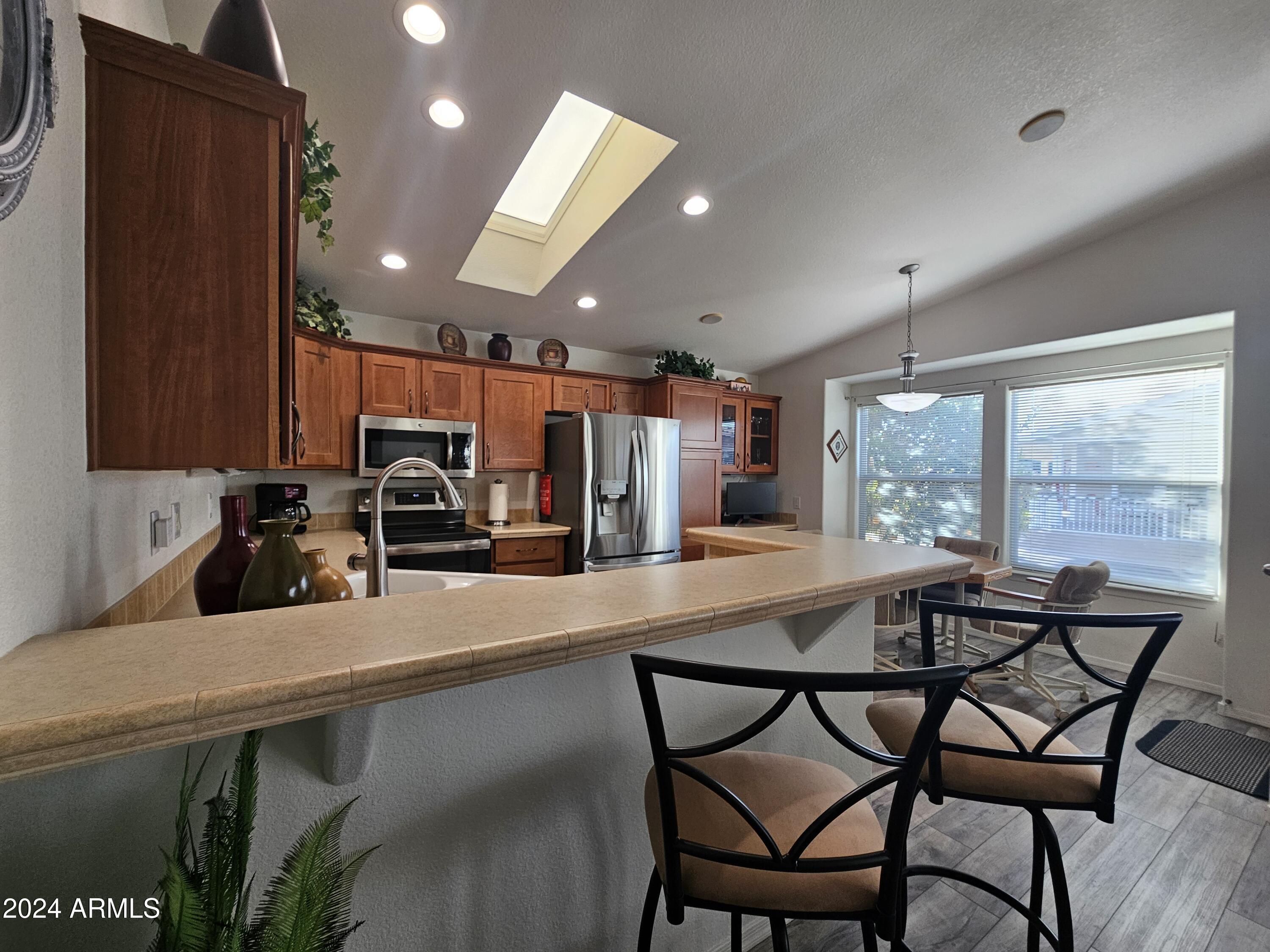 650 North Hawes Road, Unit 4412 Mesa, AZ 85207 - Photo 9 of 48 a kitchen with a table chairs cabinets and wooden floor