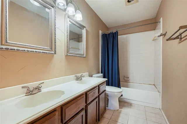 a bathroom with a double vanity sink toilet mirror and shower