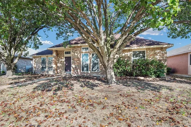 a front view of a house with a tree