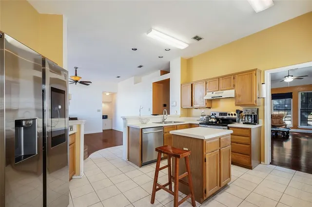 a kitchen with a stove a sink dishwasher a refrigerator and cabinets with wooden floor
