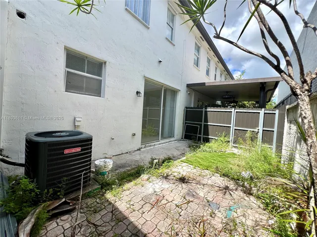 a backyard of a house with a garden and barbeque oven