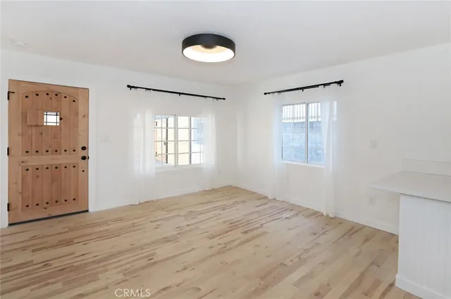 a view of a small space with wooden floor and a window