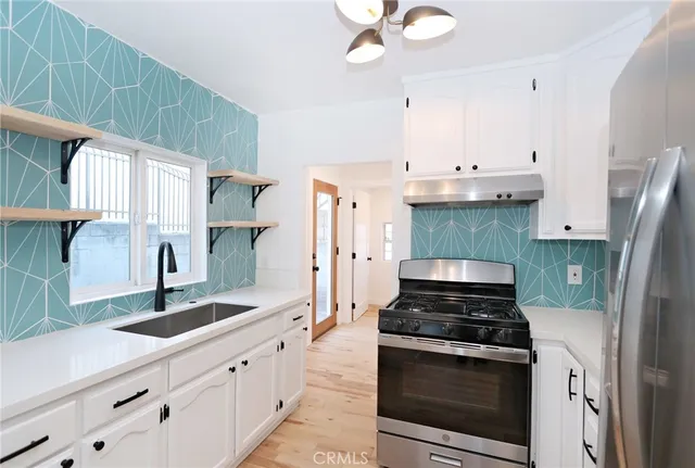 a kitchen with granite countertop white cabinets and black appliances