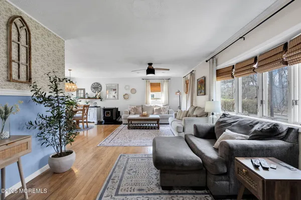 a dining room with furniture wooden floor a rug and a large window