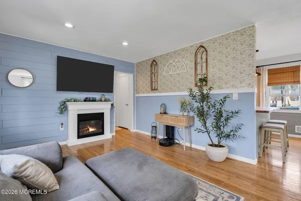 a kitchen with stainless steel appliances kitchen island a table chairs in it and wooden floor