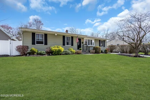 a front view of a house with a garden and trees
