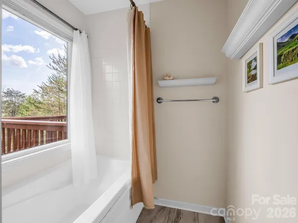 a bedroom with a bed and a large window with chair