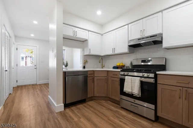 a kitchen with granite countertop wooden floors and stainless steel appliances