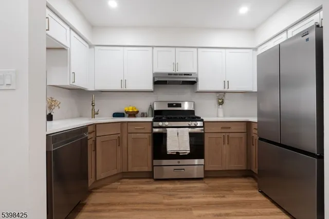 a kitchen with a refrigerator sink and cabinets