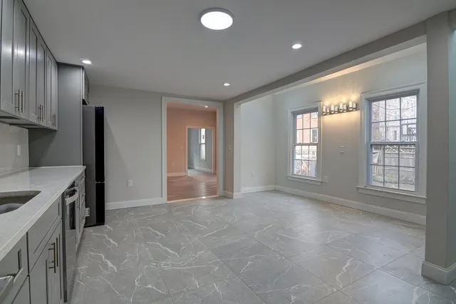 a view of a kitchen with a sink and dishwasher a refrigerator with wooden floor