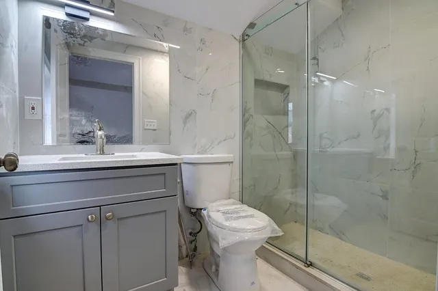 a bathroom with a sink toilet and shower