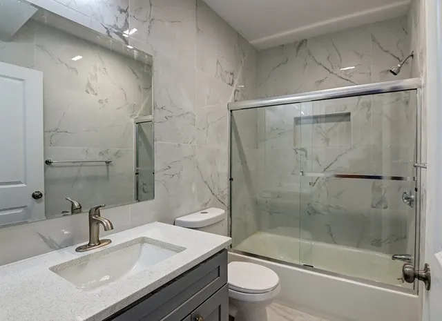 a bathroom with a sink mirror and shower