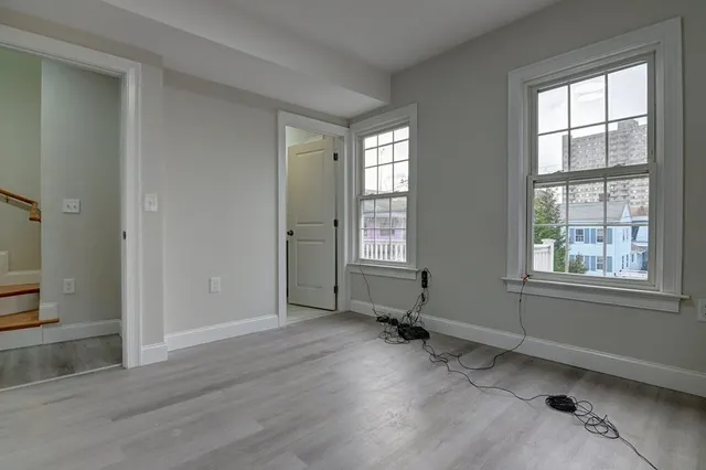 an empty room with windows and wooden floor
