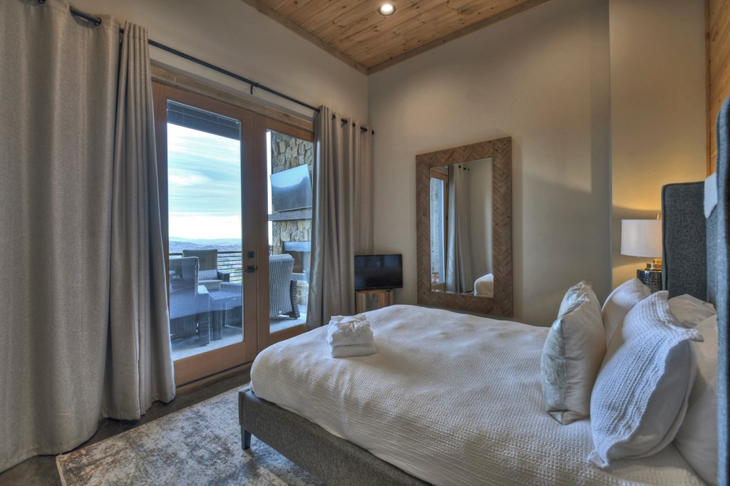 472 Overlook Drive Blue Ridge, GA 30513 - Photo 47 of 70 a bedroom with a large bed and a flat tv screen next to a window