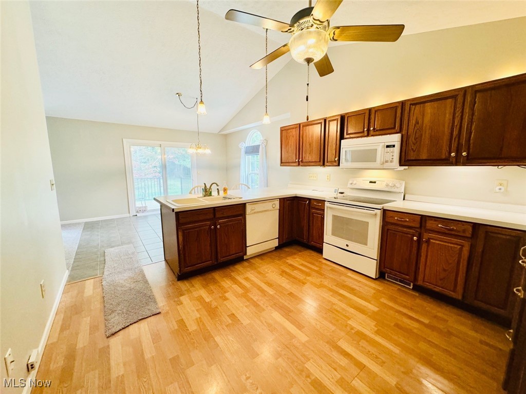 1467 Bennett Road Madison, OH 44057 - Photo 18 of 26 Kitchen with ceiling fan, light hardwood / wood-style flooring, hanging light fixtures, and white appliances
