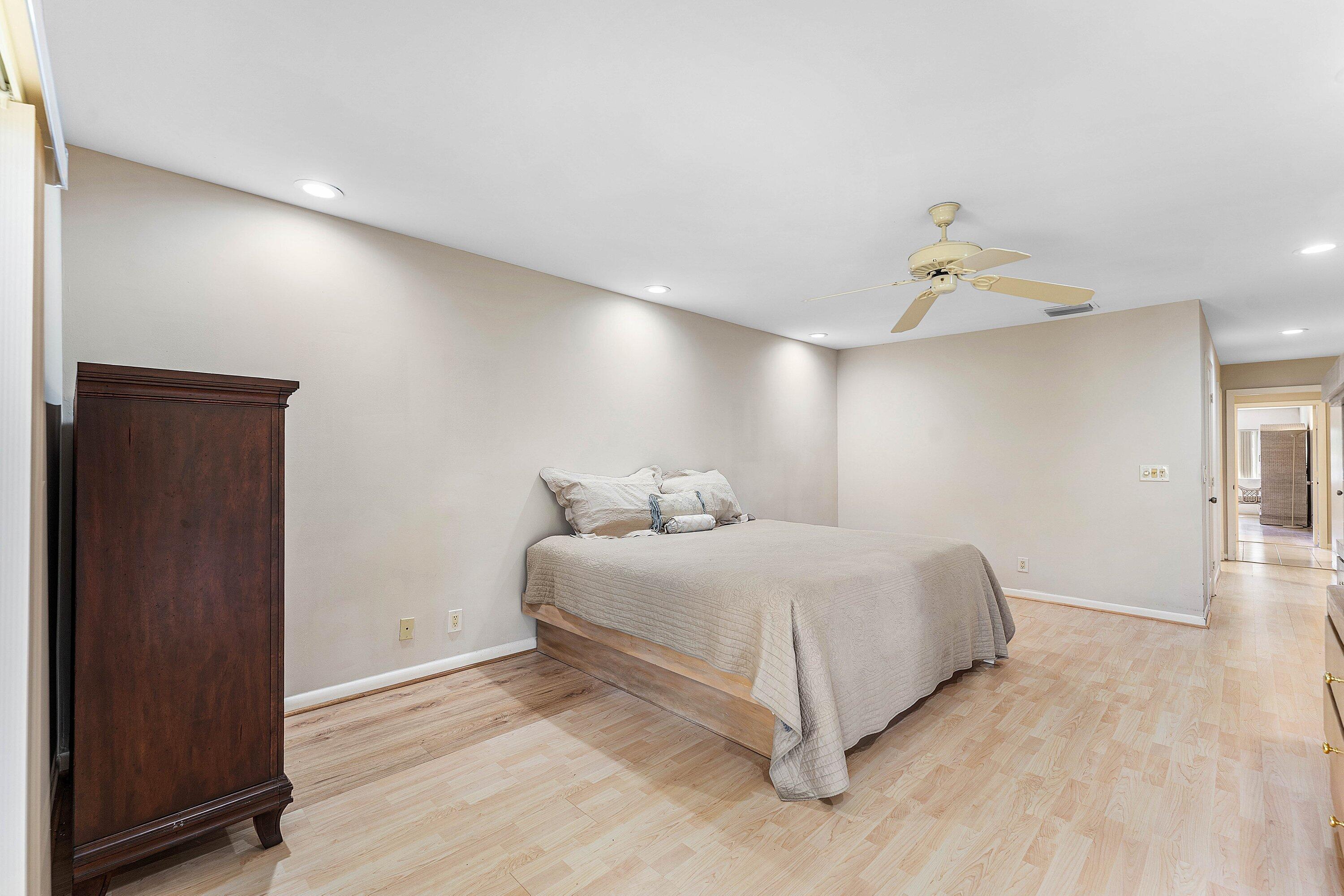 30 Hampshire Lane Boynton Beach, FL 33436 - Photo 40 of 84 a spacious bedroom with a bed and a lamp