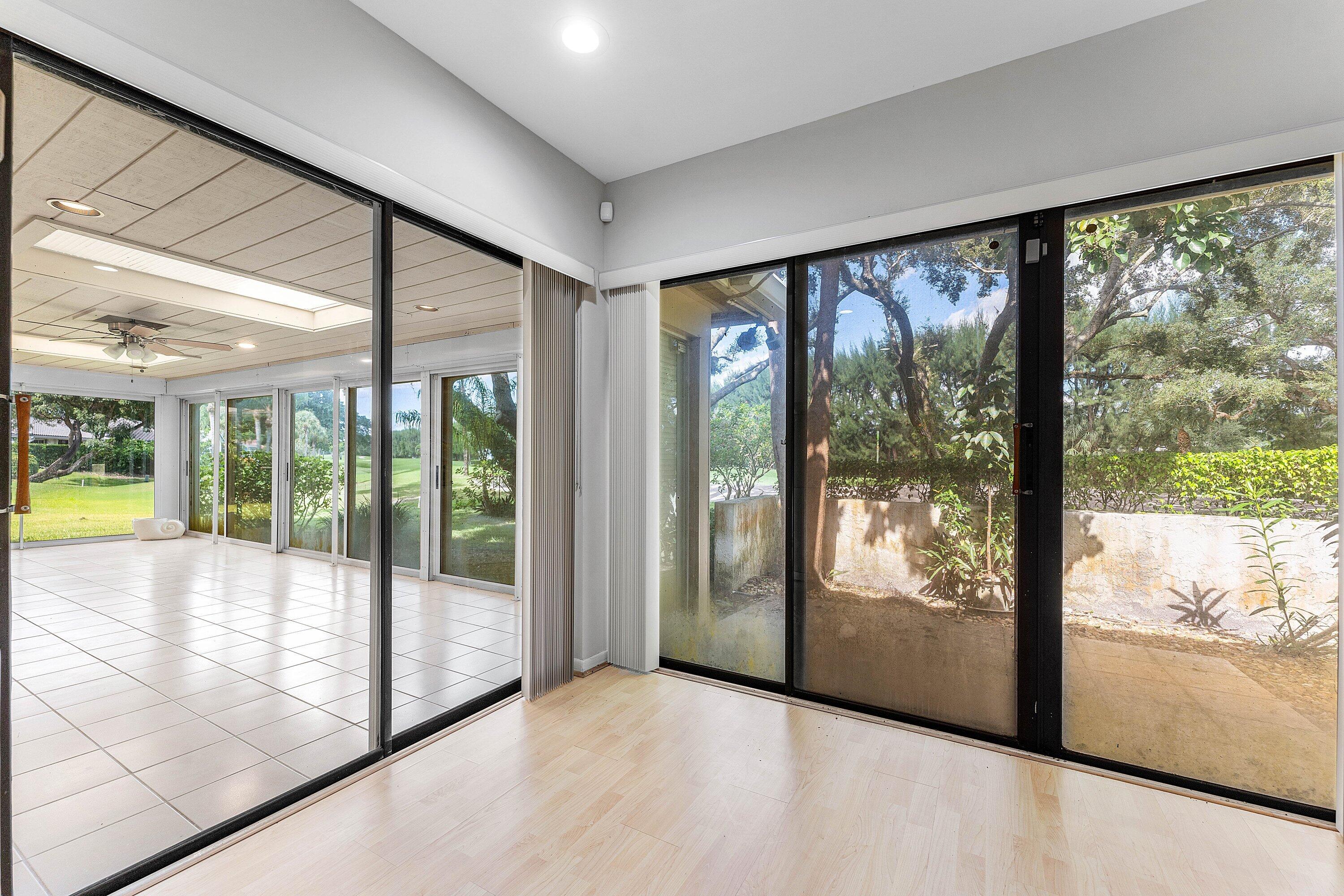 30 Hampshire Lane Boynton Beach, FL 33436 - Photo 41 of 84 a view of an empty room with wooden floor and a floor to ceiling window