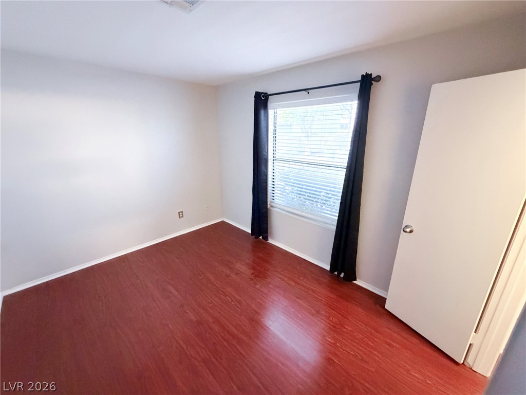 5211 South Lindell Road, Unit 105 Las Vegas, NV 89118 - Photo 9 of 19 Rich hardwood flooring pairs with a large window to create an inviting interior space.