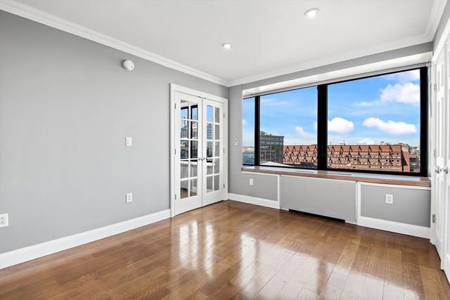 an empty room with wooden floor and windows