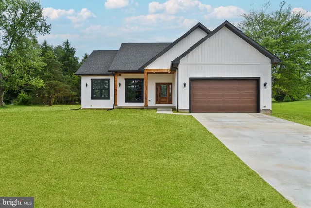 a front view of a house with yard and trees