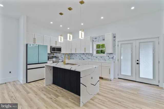 a kitchen with white cabinets and sink