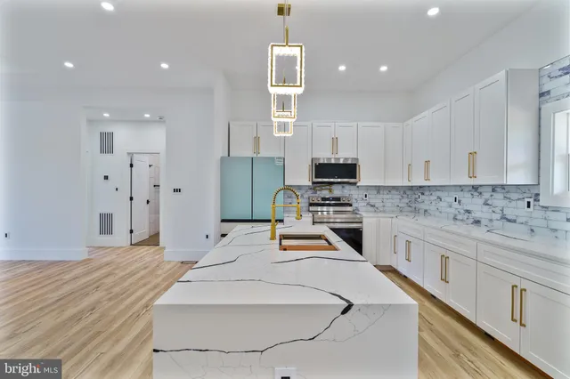 a kitchen with stainless steel appliances kitchen island granite countertop a sink and cabinets