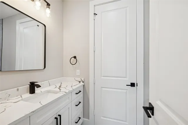 a bathroom with a sink vanity and a mirror