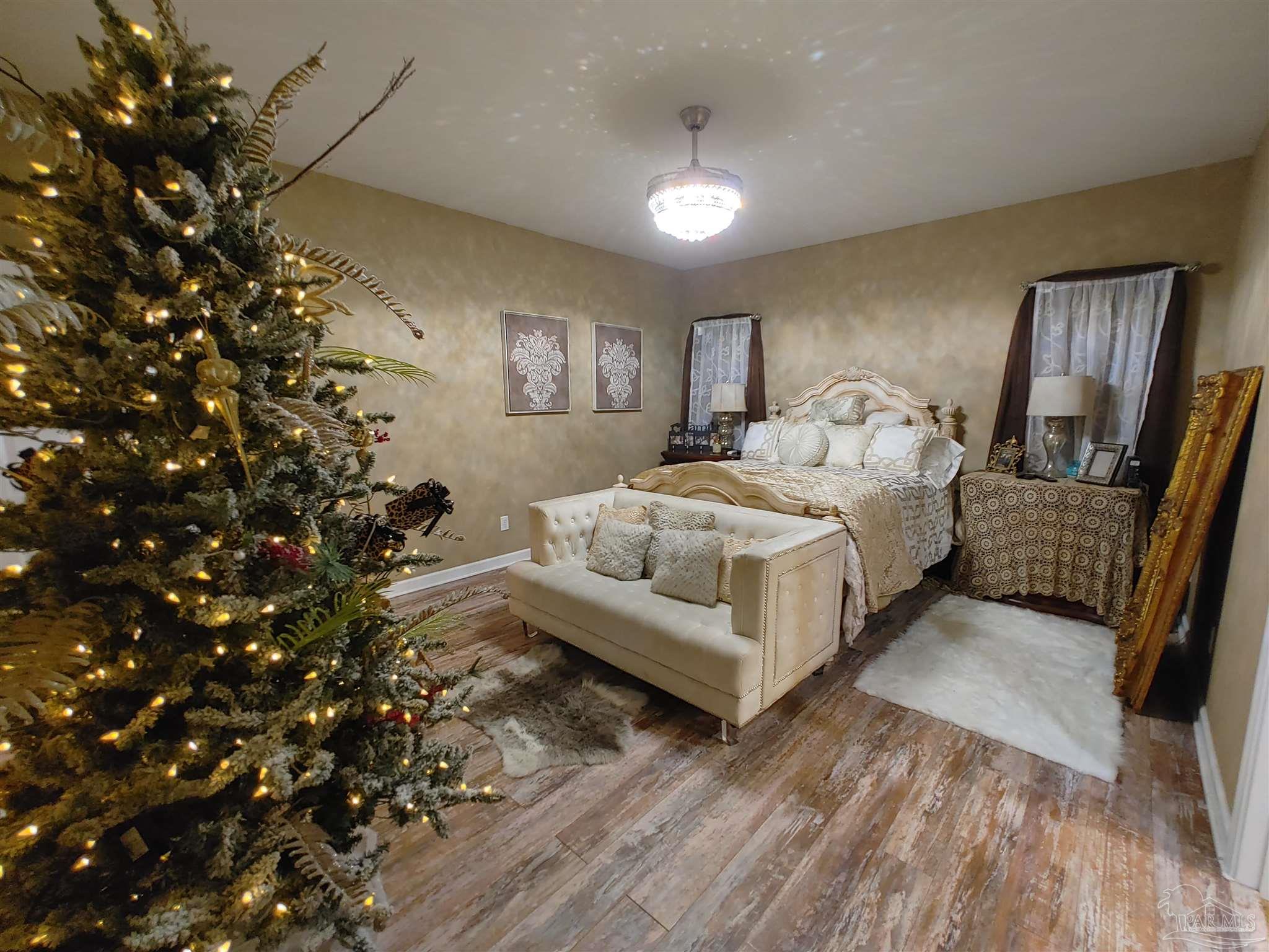 415 Clark Road Gilbertown, AL 36908 - Photo 20 of 50 a spacious bedroom with a bed and a chandelier