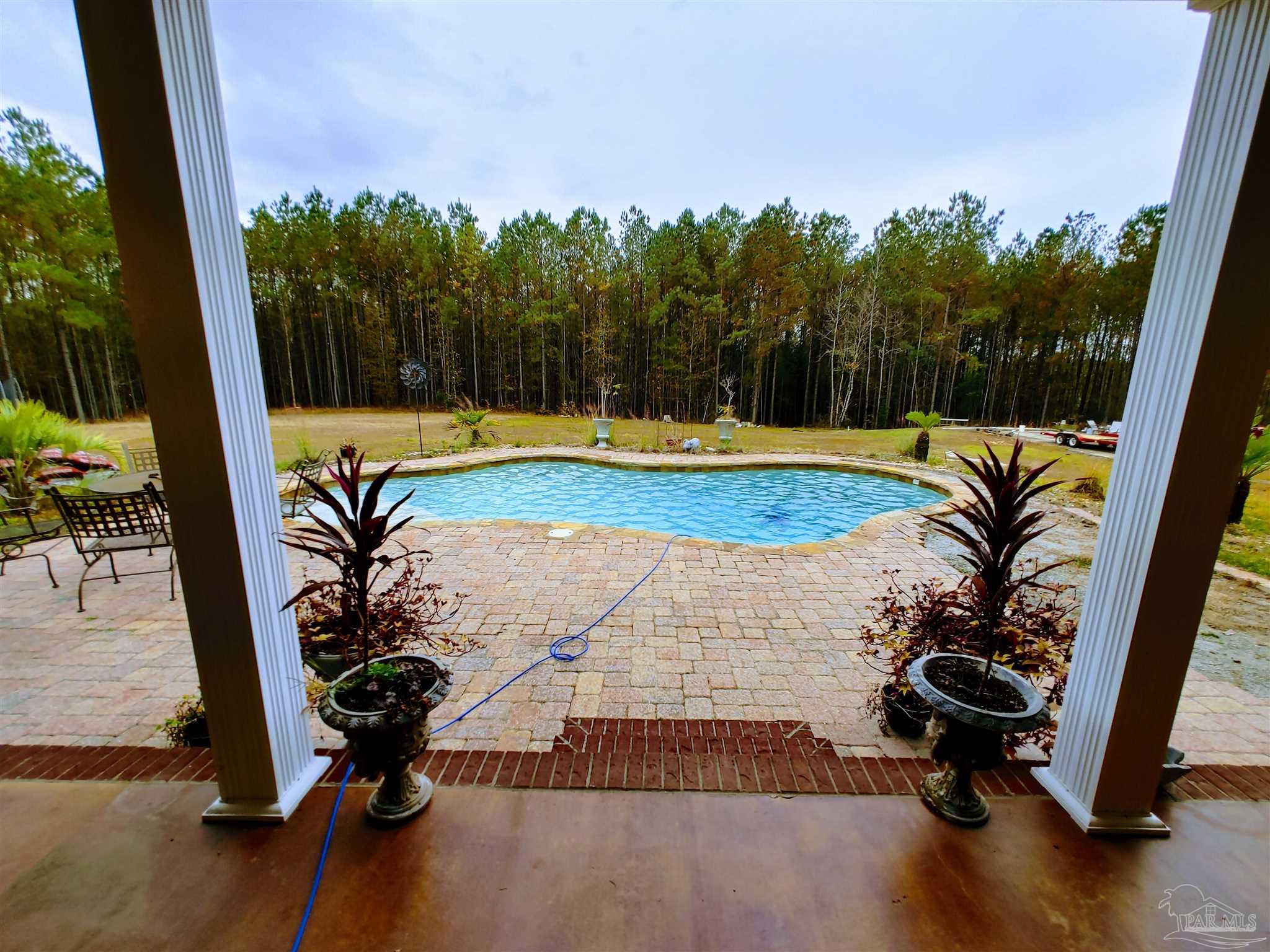 415 Clark Road Gilbertown, AL 36908 - Photo 35 of 50 a view of a swimming pool with a chair and floor to ceiling window