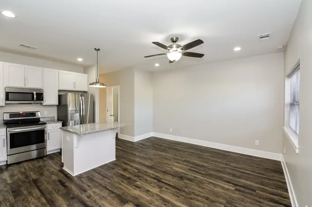 a view of kitchen with stainless steel appliances refrigerator stove microwave and cabinets