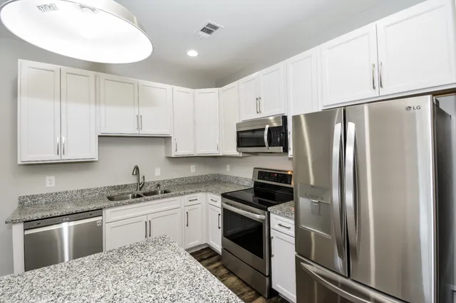 a kitchen with stainless steel appliances granite countertop a refrigerator sink and stove