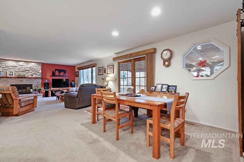 9518 Scorpio Street Boise, ID 83709 - Photo 15 of 46 Dining space with light carpet, a stone fireplace, and recessed lighting