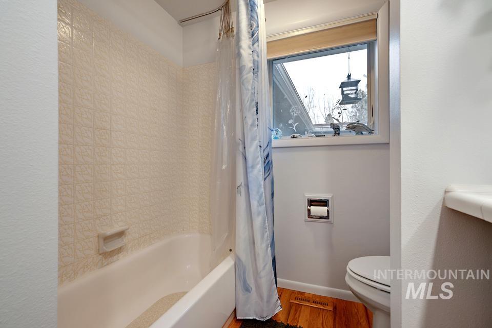 9518 Scorpio Street Boise, ID 83709 - Photo 17 of 46 Bathroom with shower / bath combo with shower curtain and wood finished floors