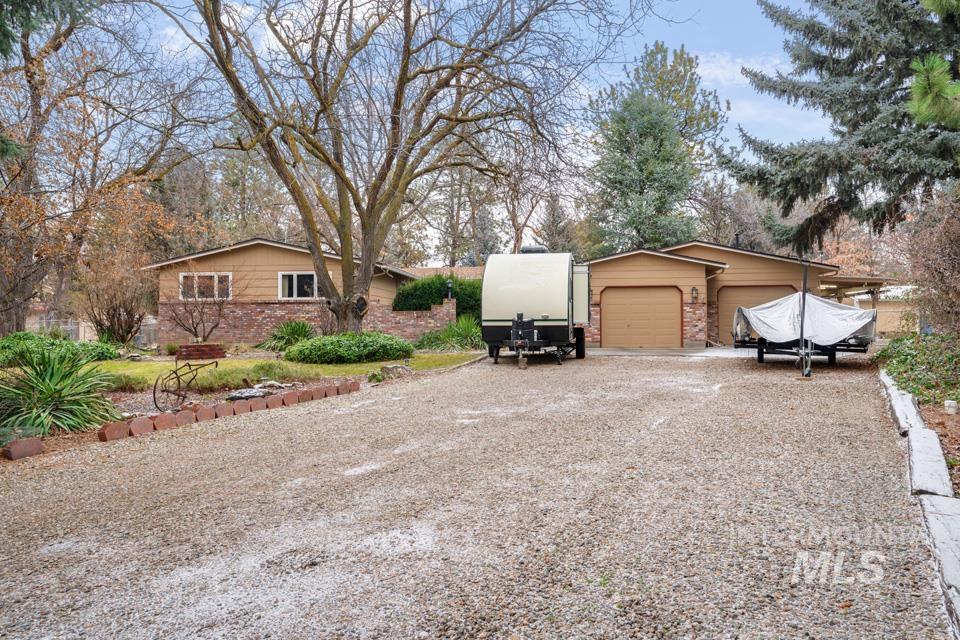 9518 Scorpio Street Boise, ID 83709 - Photo 46 of 46 View of property exterior featuring gravel driveway, a garage, an outdoor structure, and brick siding
