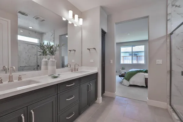 a en suite bathroom with a granite countertop sink and a mirror